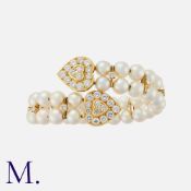 A Pearl and Diamond Bangle in yellow gold, set with brilliant cut diamonds to heart terminals and