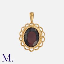 A Garnet Pendant in 9k yellow gold, set with an oval cut garnet within an openwork border.