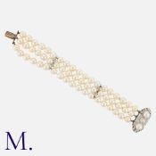 A Pearl And Diamond Bracelet in white gold, comprising three strands of pearls measuring