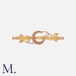 An Antique Horseshoe Brooch in 9K yellow gold with a horseshoe and leaf motif. Hallmarked for 9ct