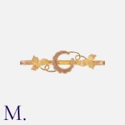 An Antique Horseshoe Brooch in 9K yellow gold with a horseshoe and leaf motif. Hallmarked for 9ct