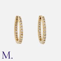 A Pair Of Diamond Hoop Earrings in yellow gold. Of hoop design, set with round cut diamonds