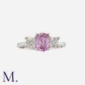 A Pink Sapphire and Diamond Ring in 18K white gold, set with an oval cut pink sapphire weighing