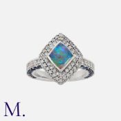 An Opal, Sapphire And Diamond Ring in 18k white gold. set with a kite shaped opal within a border of