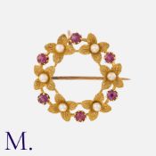 A Ruby And Pearl Wreath Brooch in yellow gold, of foliate, circular design, set with round cut