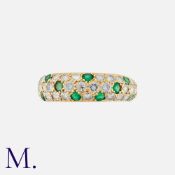 An Emerald And Diamond Ring in 18k yellow gold. Set with round cut diamonds totalling