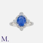 A Sapphire And Diamond Ring in 18k white gold. Set with an oval cut sapphire of approximately 1.75t,