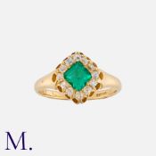 An Emerald And Diamond Cluster Ring in 18k yellow gold, set centrally with a square shaped emerald