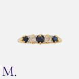 A Sapphire And Diamond Five Stone Ring in yellow gold, set with three round cut sapphires punctuated