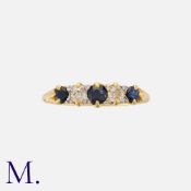 A Sapphire And Diamond Five Stone Ring in yellow gold, set with three round cut sapphires punctuated