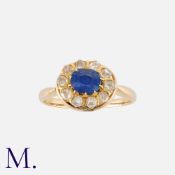 A Sapphire And Diamond Ring in yellow gold. Set with a cushion cut sapphire of approximately 0.60ct,