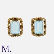 A Pair Of Aquamarine Clip Earrings in 18k yellow gold, each comprising a step cut aquamarine of
