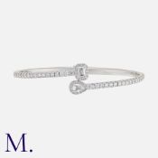 A Hinged Diamond Bangle in 18k white gold, of crossover design, set with round cut diamonds. With an