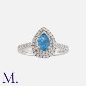 A Blue Tourmaline And Diamond Cluster Ring in 18k white gold, set with a pear shaped blue tourmaline
