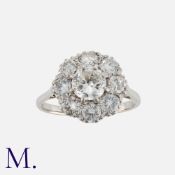 A Diamond Cluster Ring in 18k white gold, set with a central round cut diamond of approximately 1.