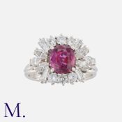 A Ruby And Diamond Cluster Ring in white gold, set with a central cushion cut ruby of