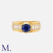 A Sapphire And Diamond Ring in 18k yellow gold, set centrally with a round cut diamond of