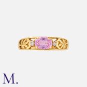 A Pink Sapphire and Diamond Ring in 18K yellow gold, set with an oval cut pink sapphire weighing