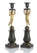 A PAIR OF ORMOLU AND PATINATED BRONZE CANDLESTICKS WITH CUPIDS