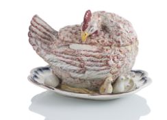A LARGE FRENCH FAIENCE TROMPE D'OEIL TURREEN AND COVER IN SHAPE OF A HEN WITH CHICKS AND EGGS
