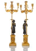 A RARE PAIR OF EMPIRE FIGURAL PATINATED AND GILT BRONZE CANDELABRA
