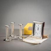 A TABLE CLOCK AND THREE CANDLESTICKS