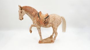 A Chinese probably Tang dynasty polychrome-patinated terracotta figure of a standing horse
