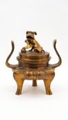 A Chinese gilt bronze tripod and covered incense burner with handles