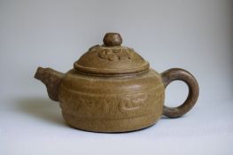 A Chinese Yixing Zisha clay teapot. Relief decorated. Signed to base and lid. 7.5 x 13cm 