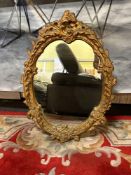 Gilt carved mirror Rococo style, featuring elaborate scroll, leaf, and floral detailing on the frame