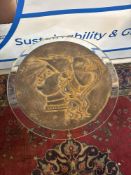 A striking bronzed resin decorative wall accessory. This piece features a circular shape,