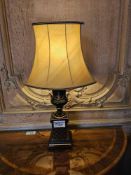 A pair of Neoclassic style decorative table lamps featuring a black and gilt urn-form body with