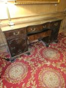 A Chippendale style mahogany twin pedestal sideboard, features a central kneehole flanked by two
