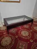A Maxine Snider style Coffee Table a dark-stained wooden frame with a clear glass tempered top and