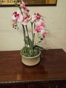 A contemporary faux floral arrangement featuring multiple stems of artificial Phalaenopsis-type