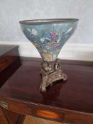 A footed bowl or jardiniere, comprising a tapering porcelain vessel set into a tripartite cast metal