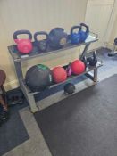 A collection of modern fitness equipment presented on a two-tier, grey painted metal utility