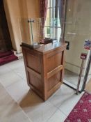 A freestanding reception or information counter, constructed from light-toned quartersawn oak,