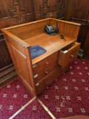 A oak reception or stand-up desk. The desk features a raised back and side panels, forming an