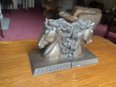 A pair of decorative bookends crafted from resin, each featuring a sculptural horse head with a