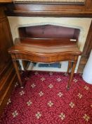 A George III style mahogany serpentine fold-over card table. The polished hardwood top features a