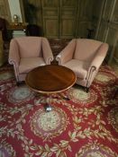 A set comprising two upholstered armchairs and a circular wooden pedestal table. The armchairs are