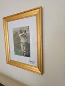 A vintage framed print sepia-toned, depicting a male golfer in early 20th-century attire mid-swing