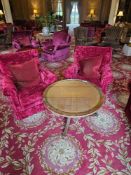 This lot presents two armchairs, accompanied by a circular coffee table. The armchairs are