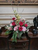 A large, decorative floral arrangement composed of artificial or 'silk' flowers and foliage,