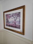 A framed landscape print depicting a central tree with foliage rendered in shades of purple and