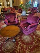 This lot comprises a pair of traditional club-style armchairs and a round pedestal side table. The
