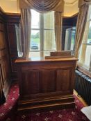 An oak reception counter traditional panelled construction and a deep plinth base. The counter is