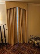 A pair of gold-toned drapes featuring full-length pinch-pleat curtains constructed from woven