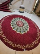 A large oval machine-woven area rug, featuring a traditional design with a prominent central